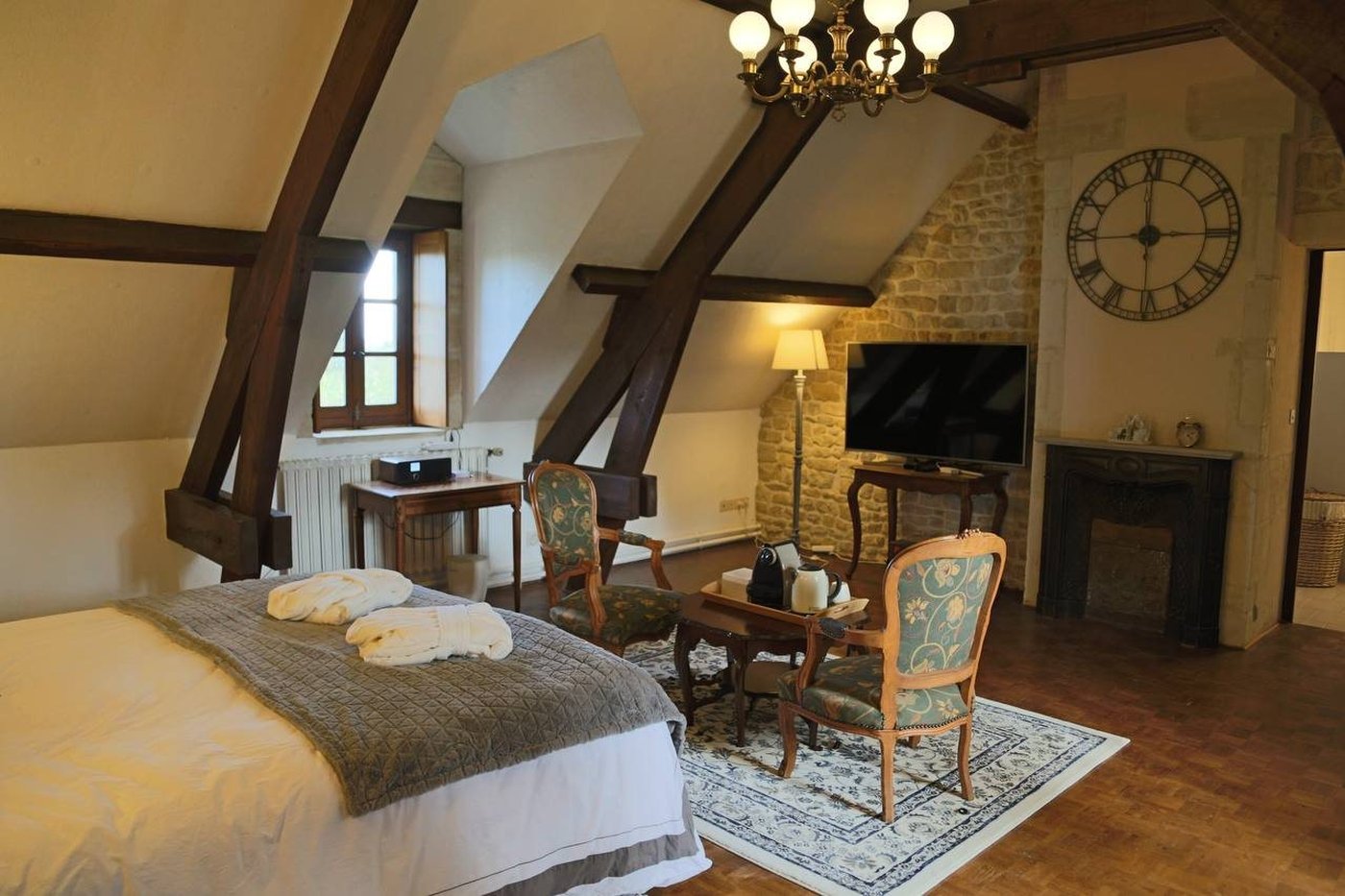 La chambre sous charpente, coin salon et cheminée