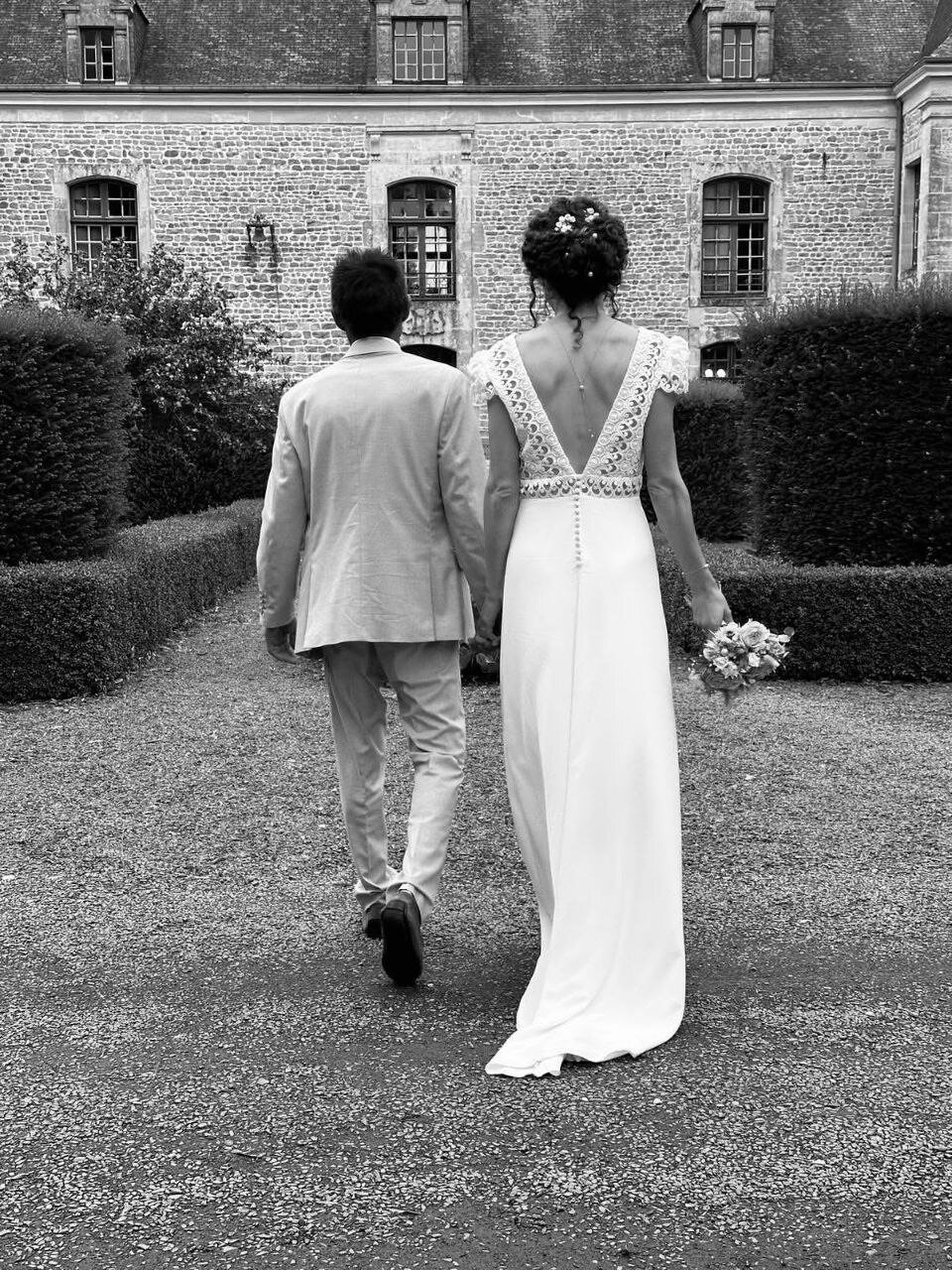 Les mariés dans l'allée, vers le château