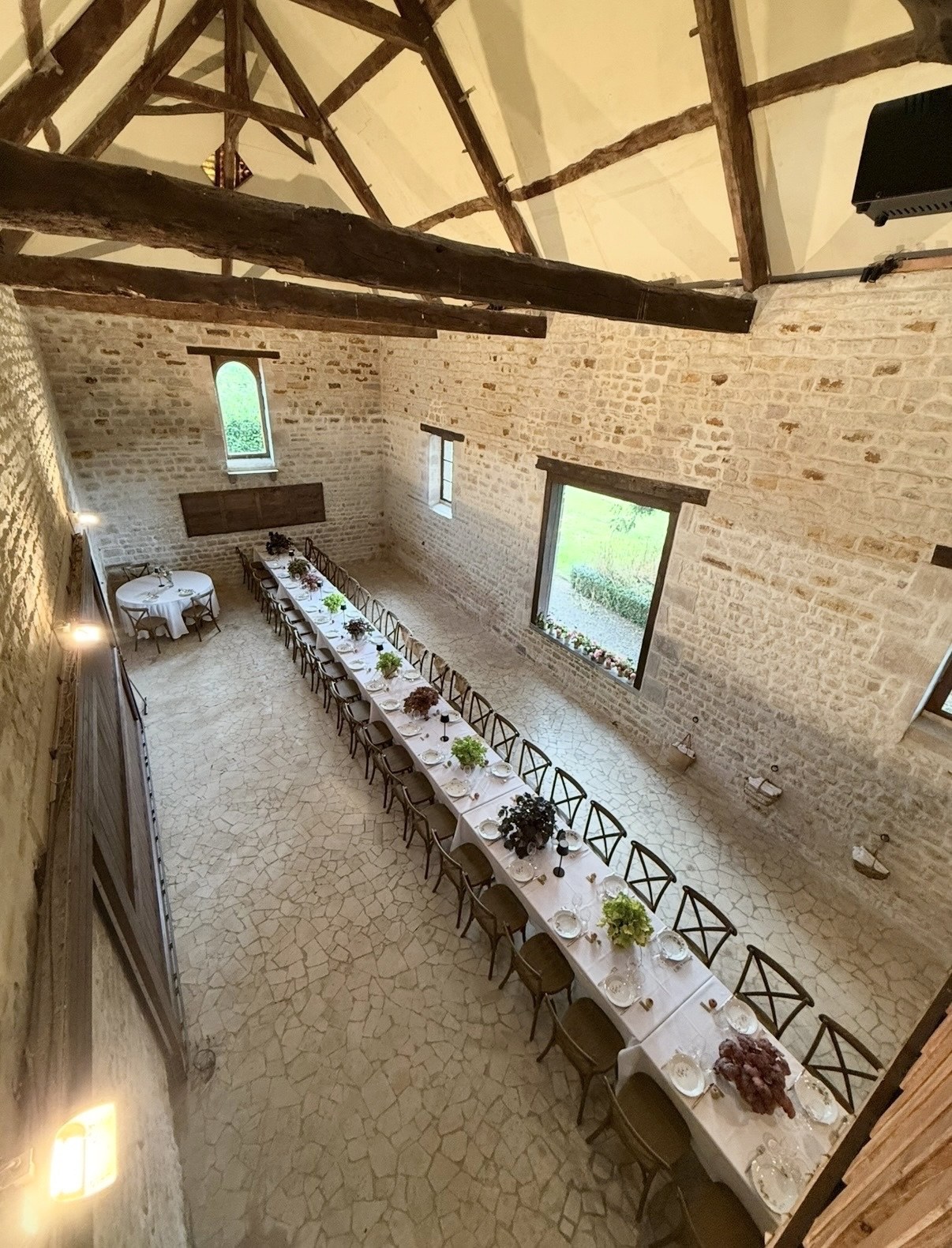Le grand salon dressé, vue d'en haut — la longue table sous la charpente